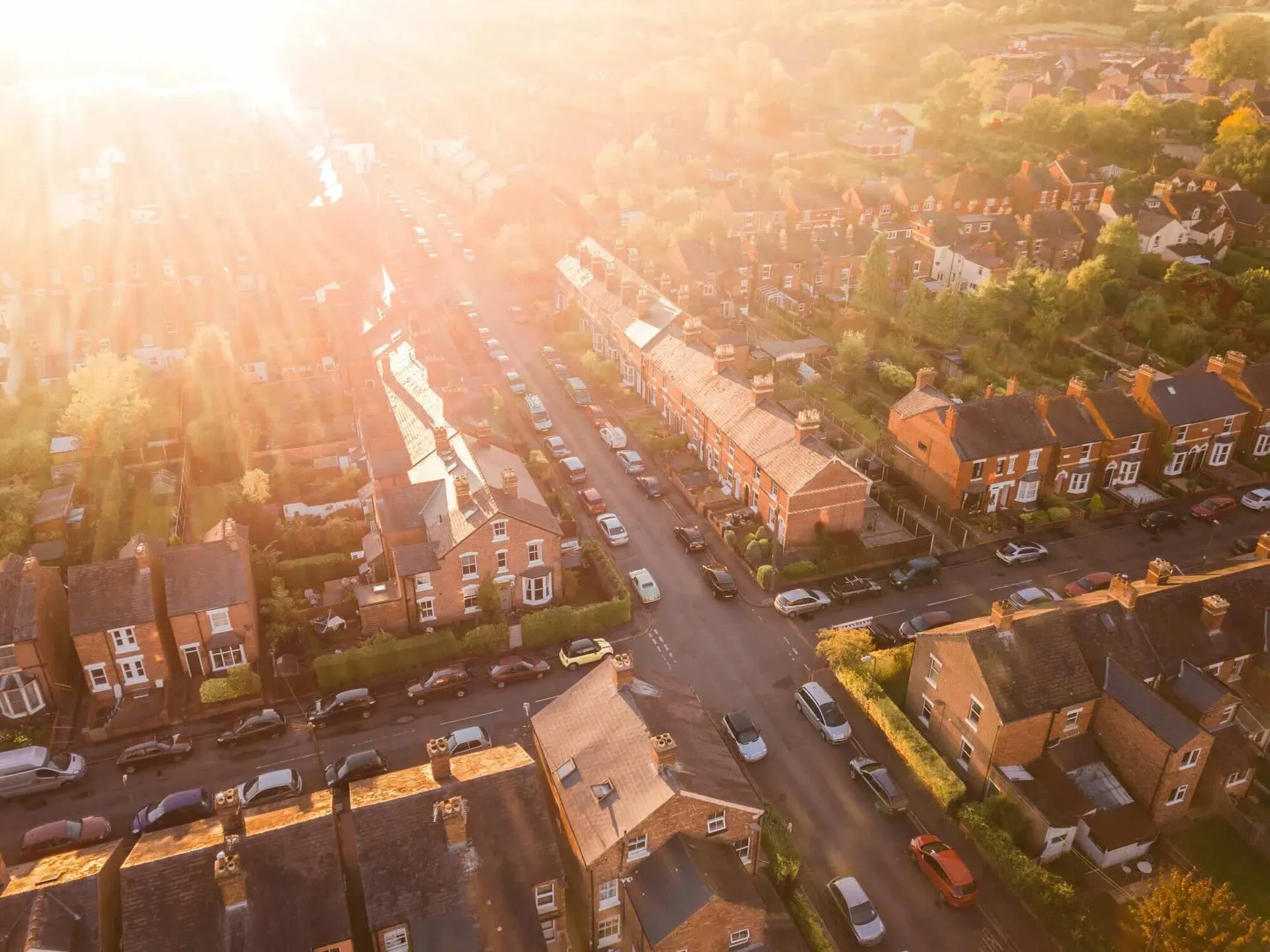 Sun setting over a traditional British neighbourhood. Lens flare and warm colours to give a homely effect.