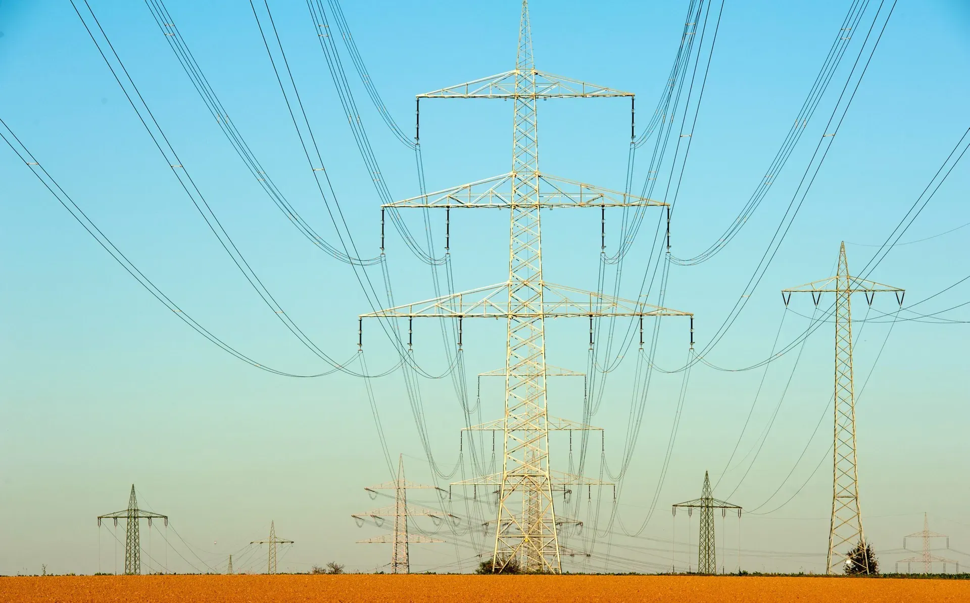 Electricity pylons in front of a sunset.